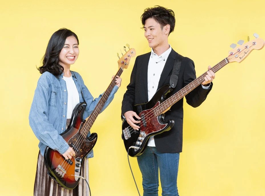 楽しそうにベースを弾く男女
